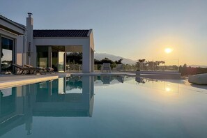 A modern house with a swimming pool, a covered patio, and a view of the mountains. - Oramia Infinity Villa with Private Heated Pool in Chania (Chania)