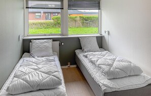 A small room with two single beds, a radiator, and a window with blinds. - Awesome home in Thyborøn with WiFi (Thyborøn)