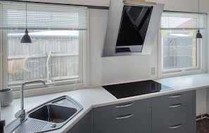 A kitchen with a built-in sink, a window with blinds, and a pendant light. - Awesome home in Thyborøn with WiFi (Thyborøn)