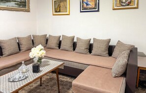 A living room with a sofa, a coffee table, and decorative pillows. - Awesome apartment in Hreljin Ogulinski with sauna (Hreljin Ogulinski)