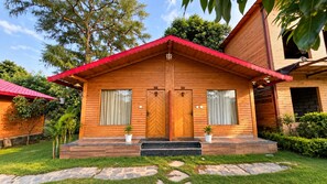 A wooden cabin with a red roof, two doors, and a small porch area.