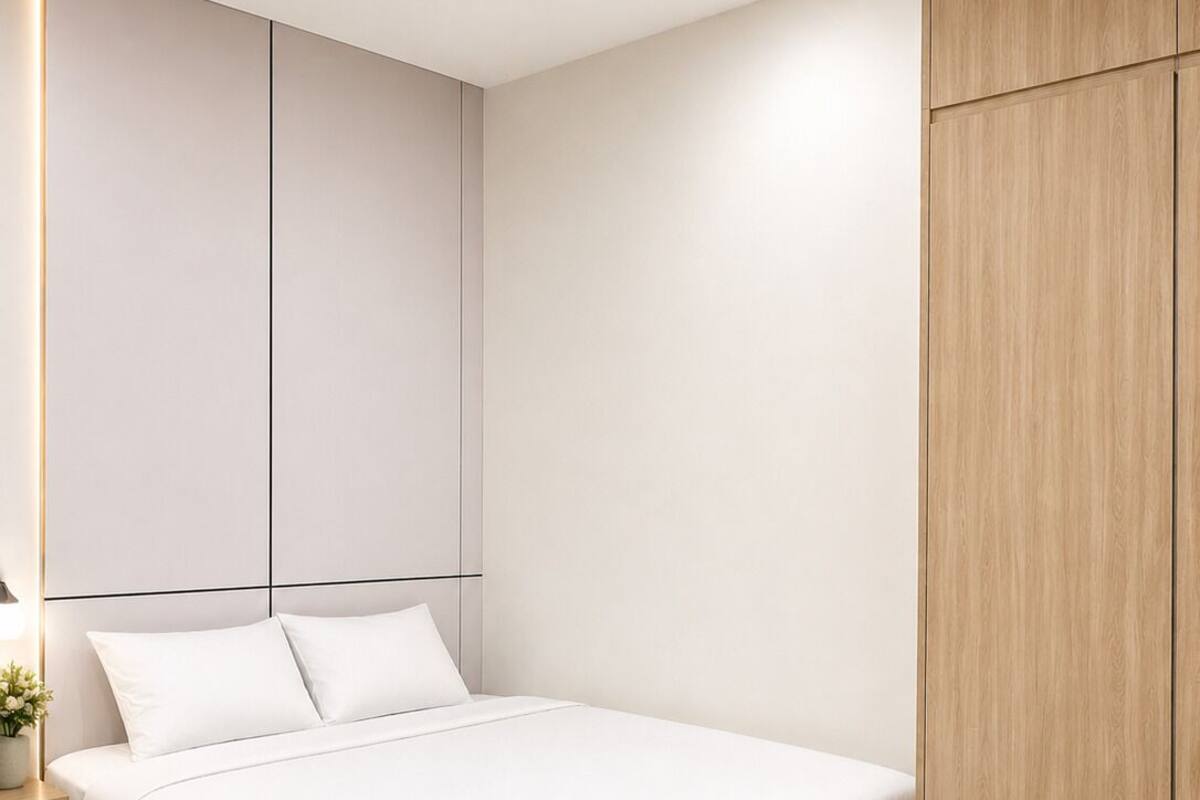 Een moderne slaapkamer met een bed, nachtkastjes en een houten garderobe.