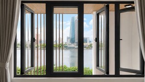 Una habitación con un ventanal amplio que da a un paisaje urbano y una masa de agua.