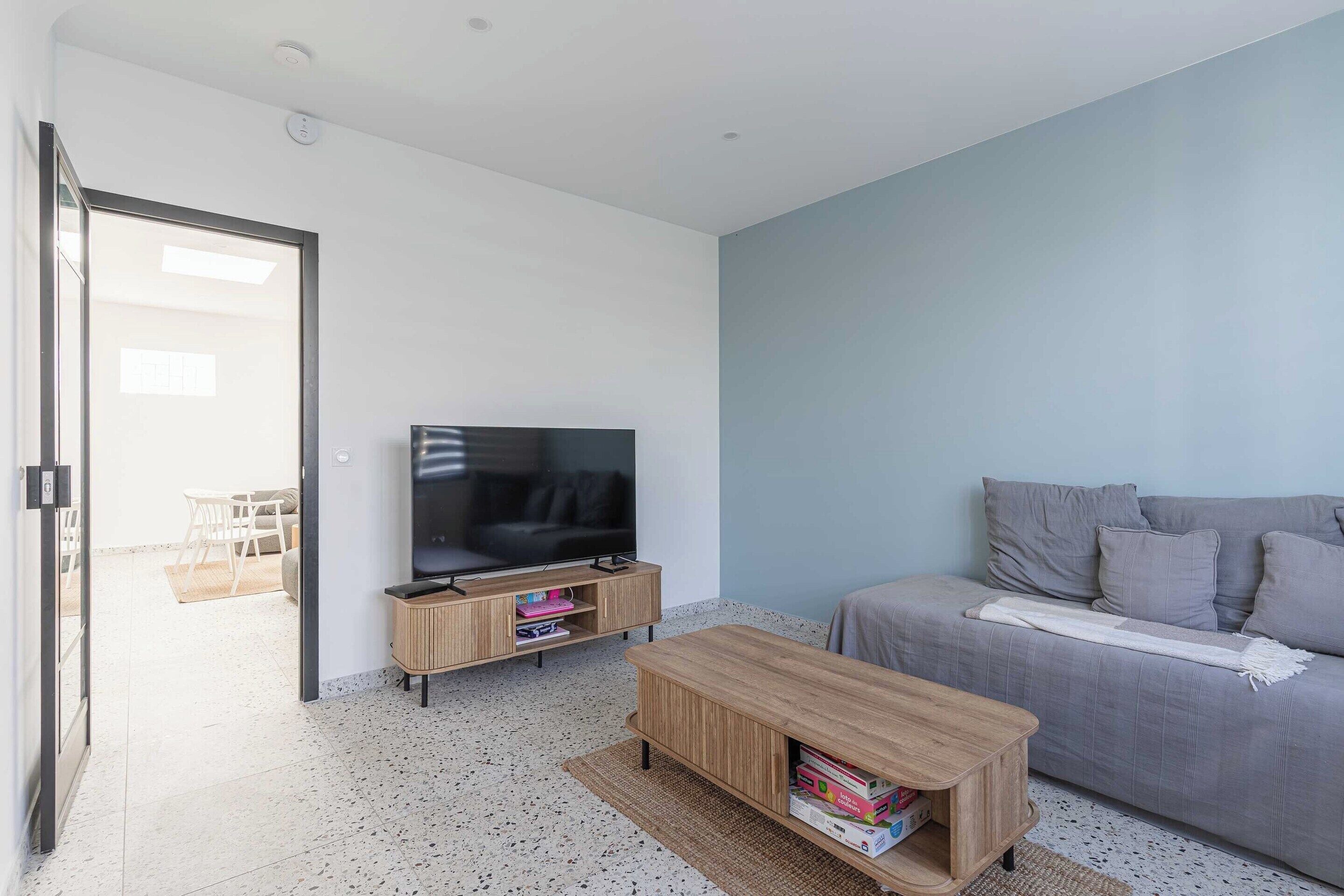 A modern living room with a TV, sofa, and coffee table.