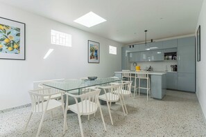 A modern kitchen with grey cabinets, a glass dining table, and white chairs. - Charming House 5br/10p Near the Sea - Benerville (Benerville-sur-Mer)