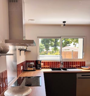 Una cocina moderna con estufa integrada, cafetera y lavavajillas.