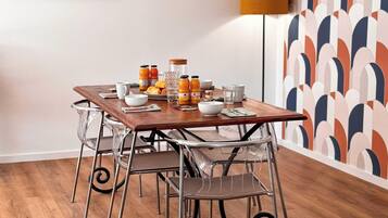 A dining area with a wooden table, metal chairs, and a mirror on the wall.