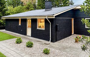 A modern single-story house with a dark exterior, a sloped roof, and a front door with windows. - Cozy home in Ebeltoft with WiFi (Ebeltoft)