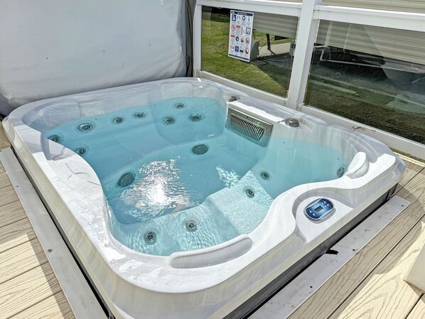 A hot tub with multiple jets, a control panel, and a safety sign on the window. - Skegness Fields 107 - UKC9565 (Skegness)