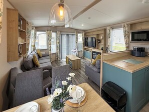 Ein kompakter Wohnbereich mit Sofa, Esstisch und Küchenzeile.