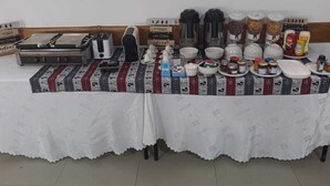 Ein Frühstücksbuffet mit verschiedenen Speisen und Getränken auf einem Tisch mit gemustertem Tischläufer.