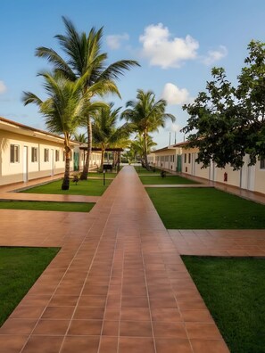 A pathway leading to a building with a tiled roof and a green lawn. - Casa Erica (Soyo)