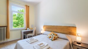 A hotel room with a bed, a desk, a chair, a radiator, and a window with curtains. - Girasole Room – Poggio alla Luna with Mountain View and Wi-Fi (Gerfalco)