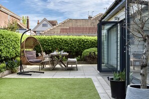 A patio with a dining table, chairs, and a hanging chair. - 2 Pier Avenue - Whitstable , Kent (Whitstable)