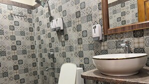 Een badkamer met toilet, wastafel en douche.