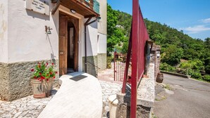 Un edificio con puerta de madera, planta en maceta y un letrero en la pared.