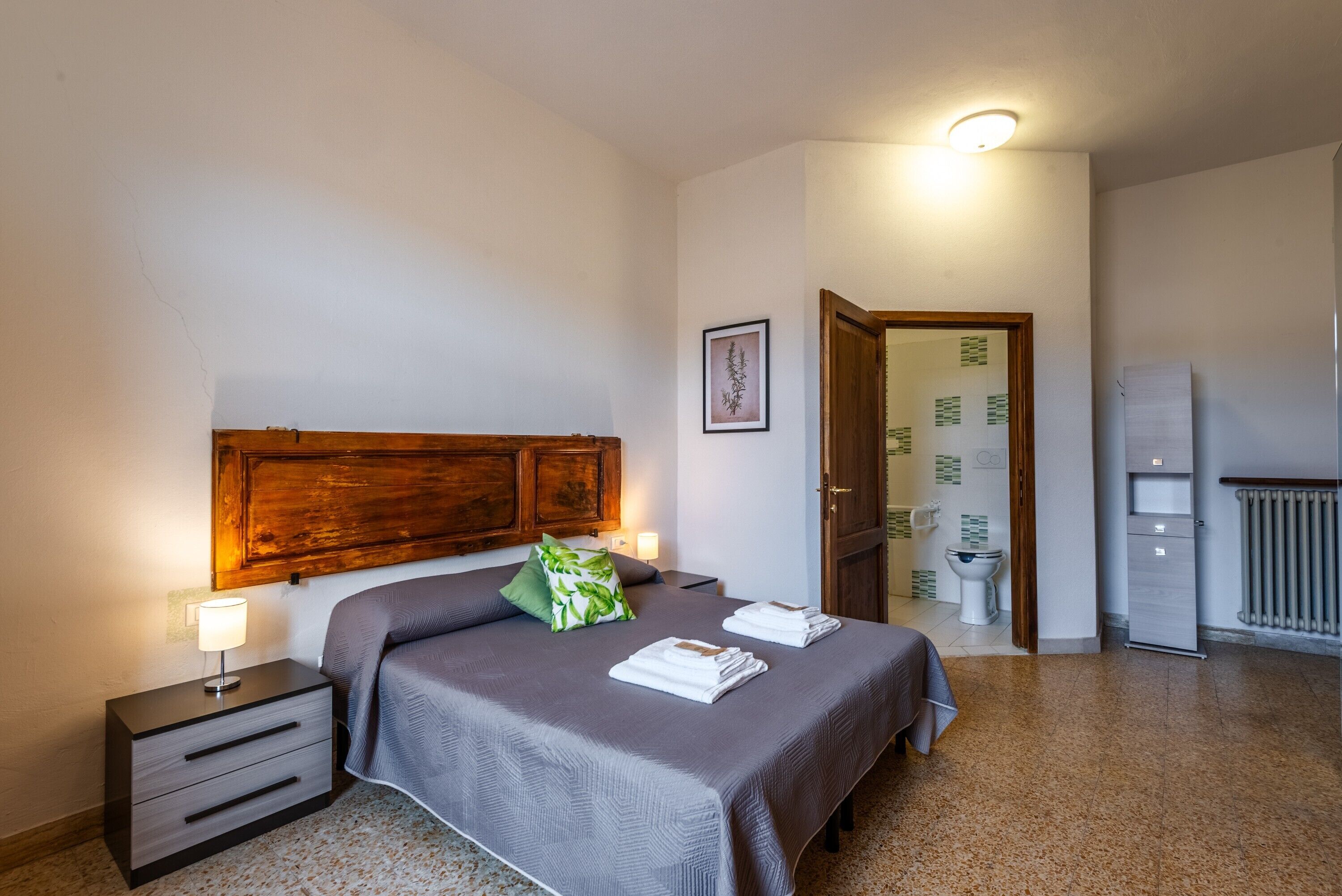 Ein Schlafzimmer mit einem Bett, einem Nachttisch und einem hölzernen Kopfteil.
