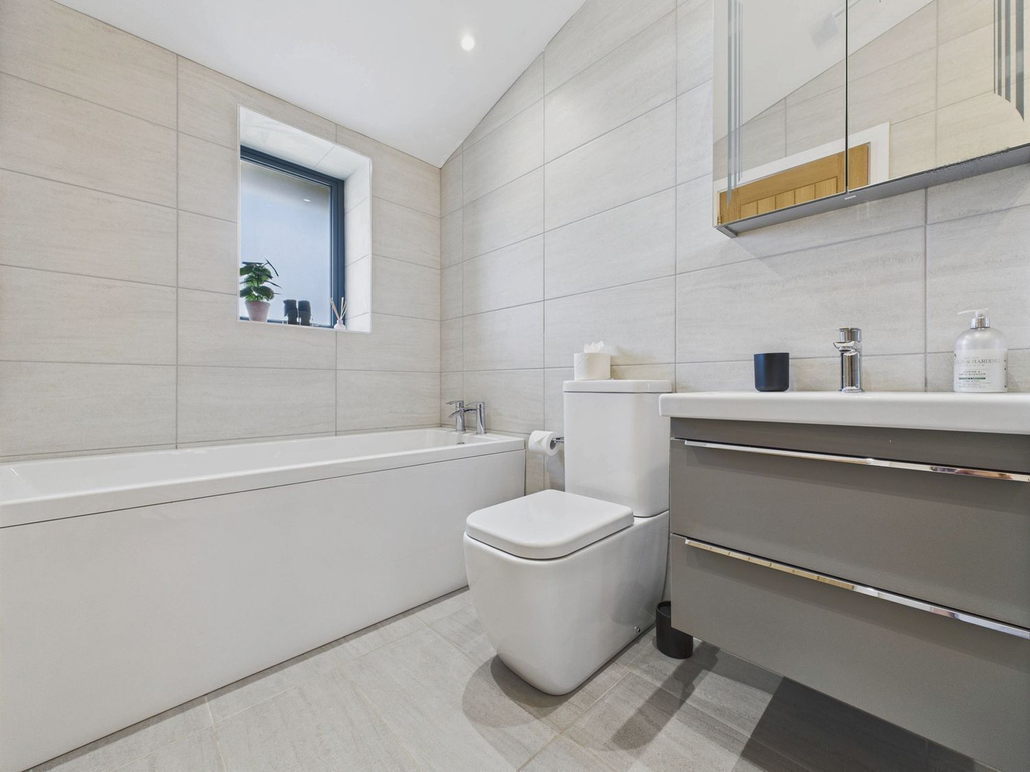 Un baño moderno con bañera, inodoro y tocador.