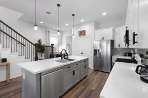 Kitchen: Sleek quartz counters and modern appliances await your culinary adventures in Texas! - NRG Access | Sleeps 10 | Near The Heights (Houston)