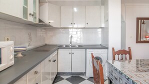 A kitchen with white cabinets, a microwave, a sink, and a dishwasher. - Paqui 1A Apartment - Families Only (Conil de la Frontera)