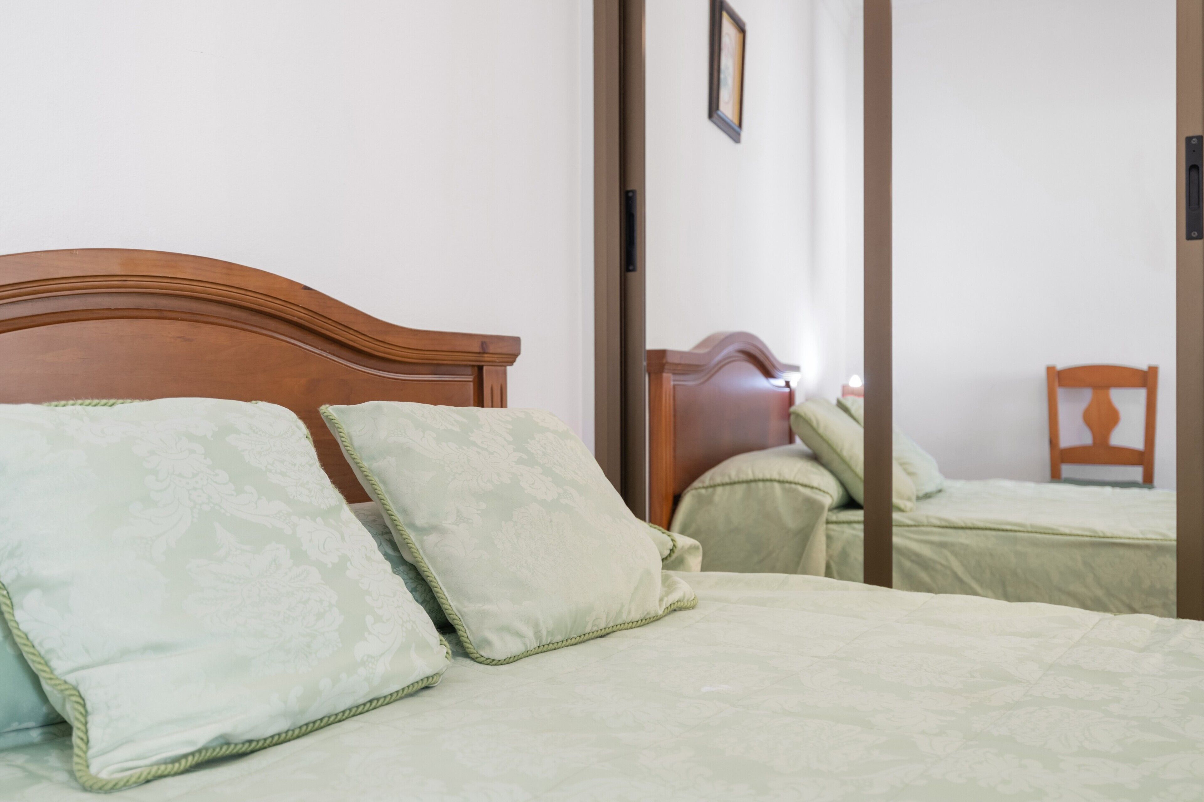 Ein Zimmer mit einem Bett, einem Sessel und einer Tür.