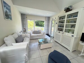 Ein Wohnzimmer mit einer Couch, einem Couchtisch, einer Vitrine und einem Fernseher.