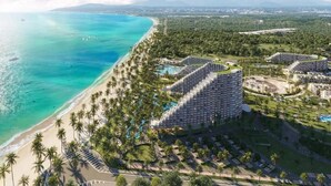 Un resort con acceso directo a la playa, áreas de piscina y un edificio circular distintivo.