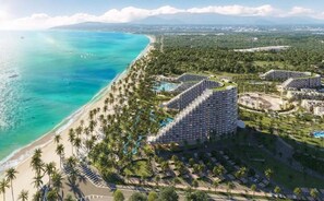 Un resort con acceso directo a la playa, áreas de piscina y un edificio circular distintivo.