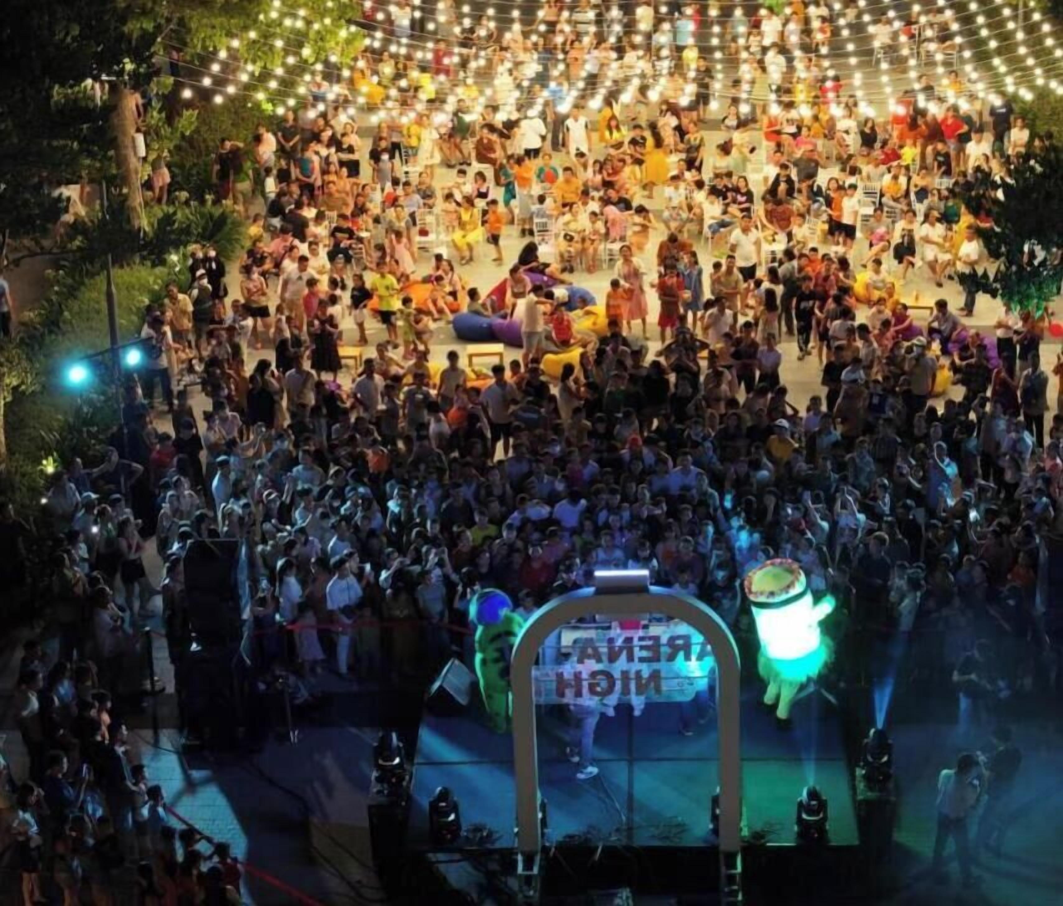 A crowded outdoor event with a stage and audience.