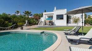 Una piscina con lettini e una zona prendisole.