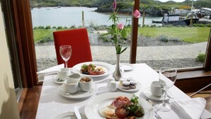 Una tavola apparecchiata per la colazione con vista su un lago e barche.