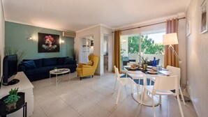 Ein modernes Wohnzimmer mit einer Couch, einem gelben Sessel, einem Esstisch und Stühlen.