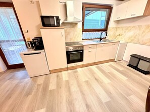 Eine kleine Küche mit Mikrowelle, Backofen und Spüle.