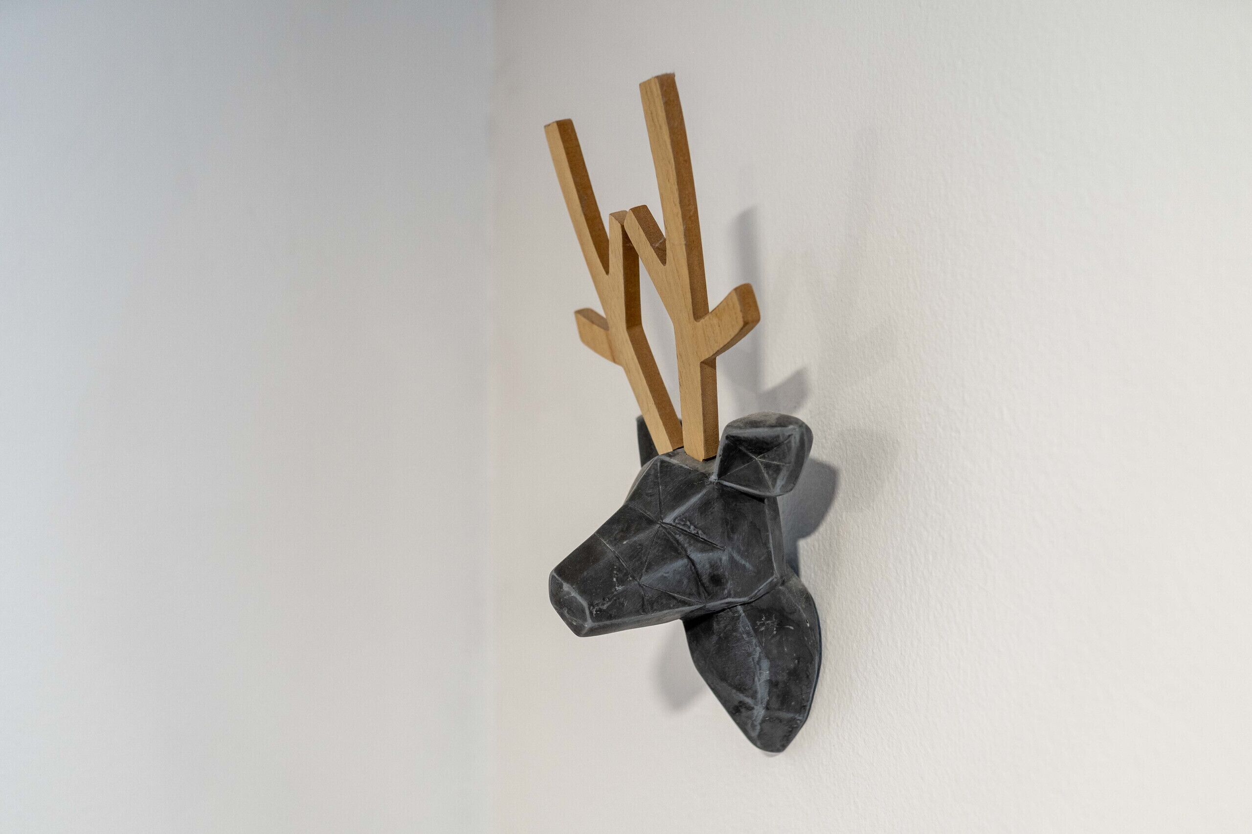 Een decoratief paneel van hout en steen, bevestigd aan de muur.