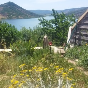 A natural landscape with a body of water, hills, and a wooden staircase. - Apartment "Les Trésors Du Lac" with Lake View, Wi-Fi and Air Conditioning (Celles)