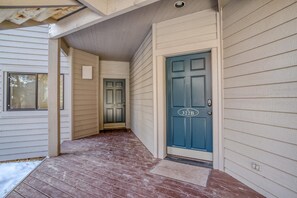 A narrow wooden hallway with a blue door marked '322B' and a small window to the left.