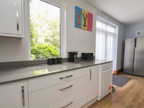 Eine moderne Küche mit weißen Schränken, einer Kaffeemaschine und einem Toaster auf der Arbeitsfläche.