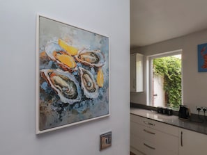 A modern kitchen with white cabinets, a countertop, and a window with a view of greenery. - 44 Love Lane (Whitby)
