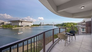 A balcony with a view of a river, a bridge, and a building with a dome.