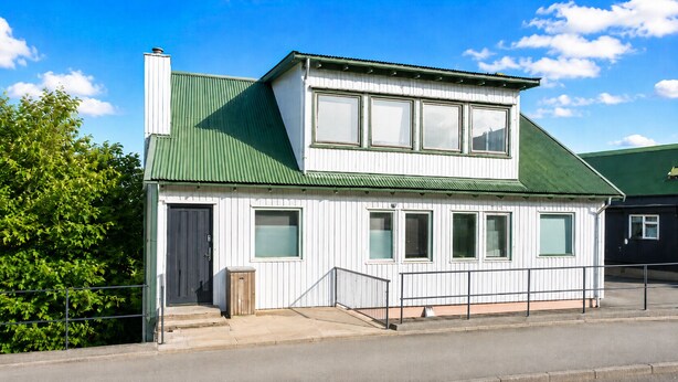 A single-story building with a green roof, a front door, and a small porch. - Modern Studio in Central Tórshavn (Tórshavn)