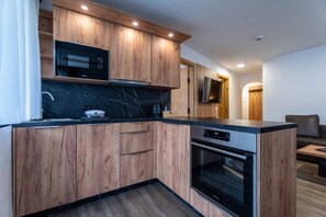 Una cocina moderna con armarios de madera, un microondas integrado y un horno de acero inoxidable.