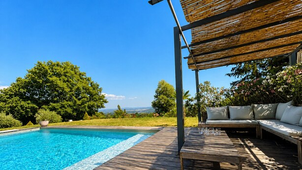 A wooden deck with a pool, a covered seating area, and a view of the landscape. - Villa Between Sky & Paradise - Pool & Valley View (Montfuron)