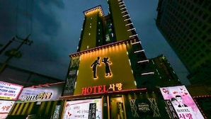 Un hotel con un cartel llamativo que muestra la silueta de un hombre y una mujer, lo que indica que es ideal para familias.