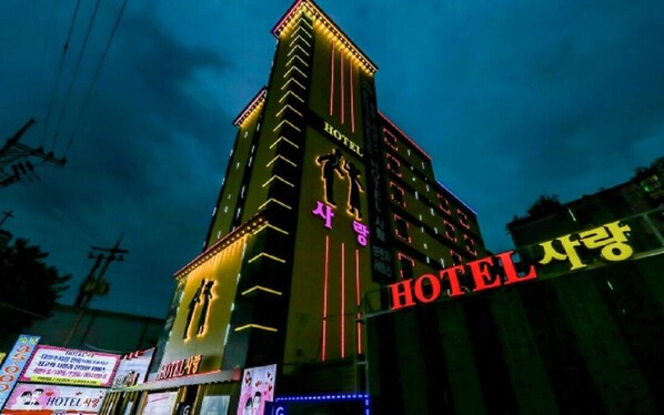 A multi-story hotel with illuminated signage and a prominent 'HOTEL' sign on the facade. - Hotel Sarang (Cheonan)