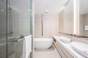 A modern bathroom with a glass-enclosed shower, a freestanding bathtub, and two sinks. - LaneStay - Grand Prix Retreat w Pool, Gym, Parking (Melbourne)