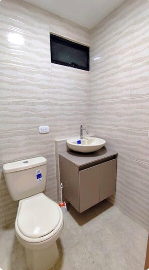 Ein Badezimmer mit Toilette, Waschbecken und Schrank.