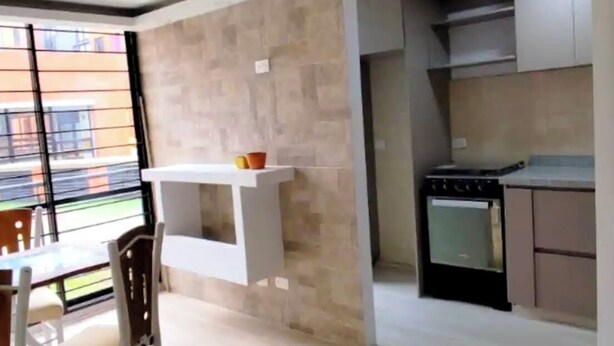 A modern kitchen with a stove, oven, and white cabinets. - Cozy apartment ideal for travelers, digital nomads, or families. (Bogotá)