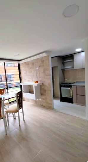 Una cocina moderna con estufa, horno y armarios blancos.