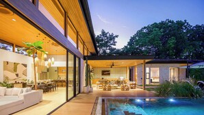Une maison moderne dotée d’une piscine, d’un coin repas et d’un salon.