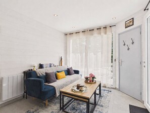 Ein modernes Wohnzimmer mit Sofa, Couchtisch und einer Tür mit Haken.